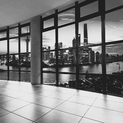 Skyline view of Shanghai at dusk, featuring illuminated skyscrapers and urban waterfront architecture.